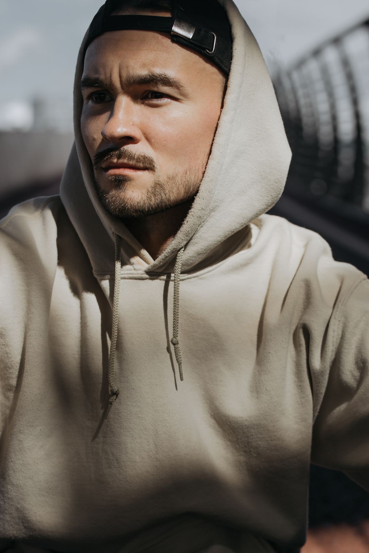 キャップとフードで頭部を覆った男性