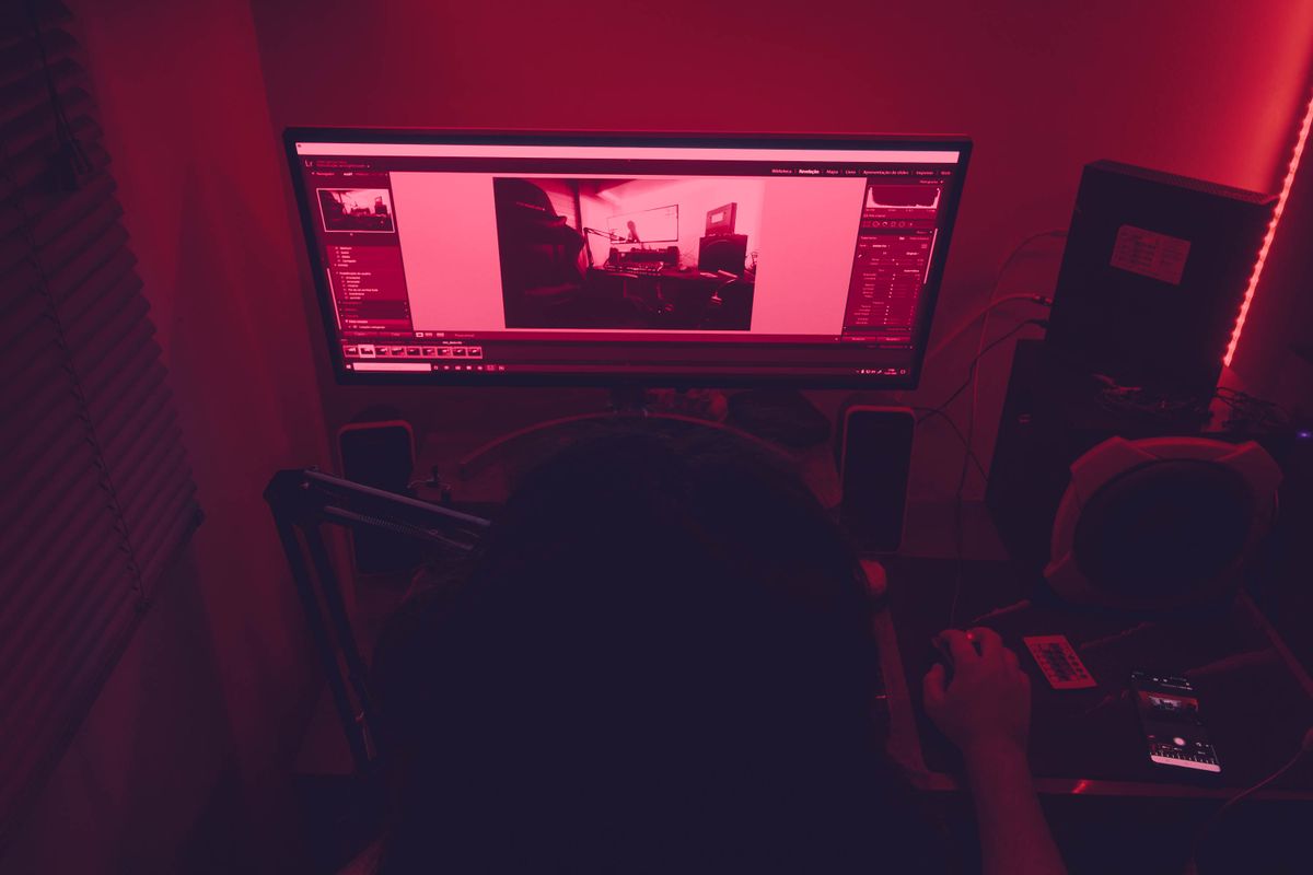 暗い部屋でパソコンに向かう人物