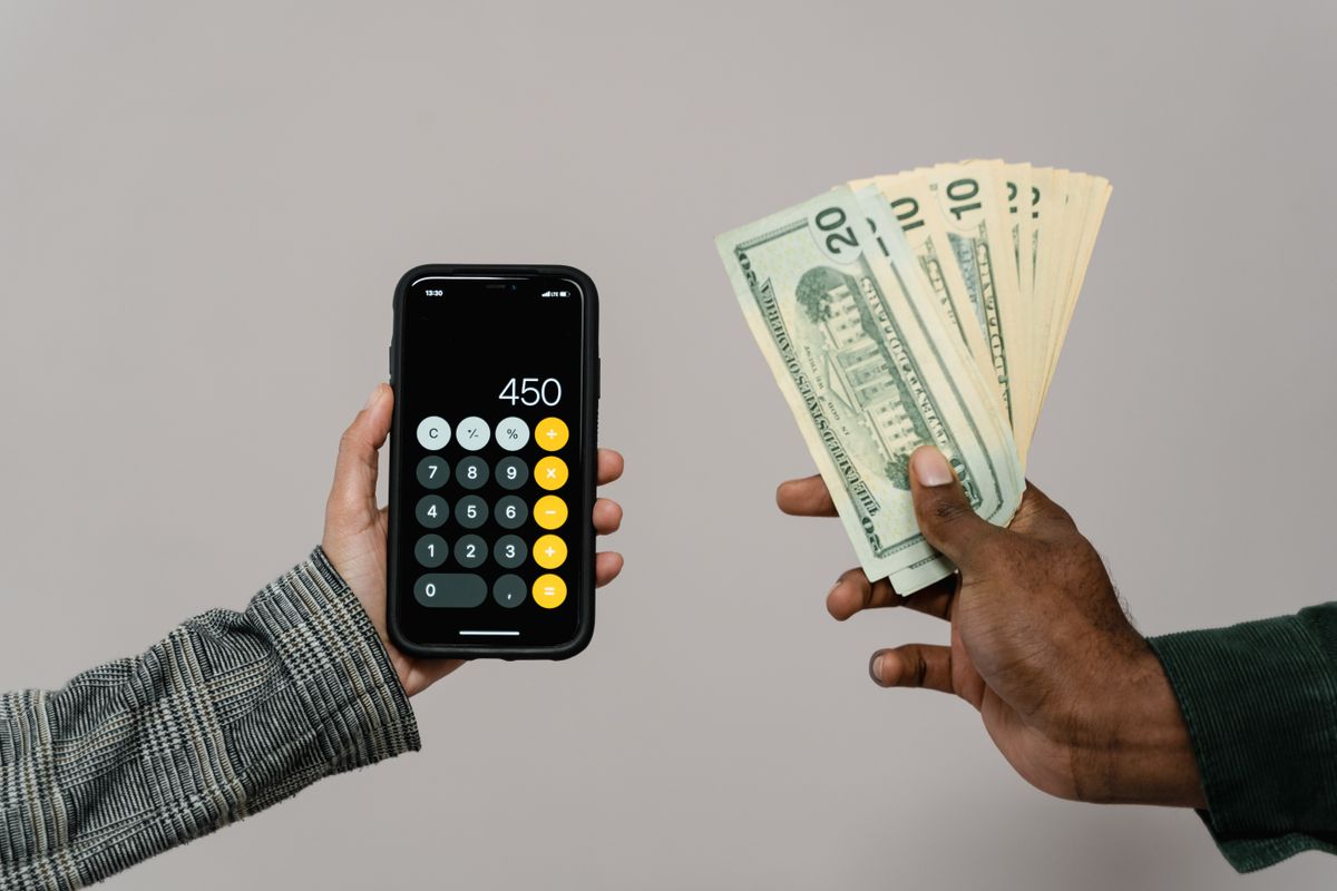 現金とスマホ電卓で費用を計算する手