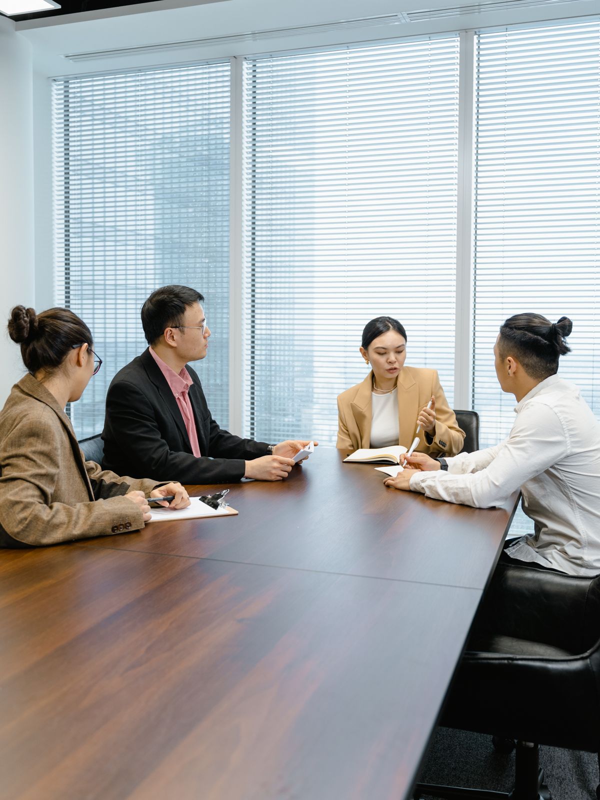会議室で向き合って話す人たち